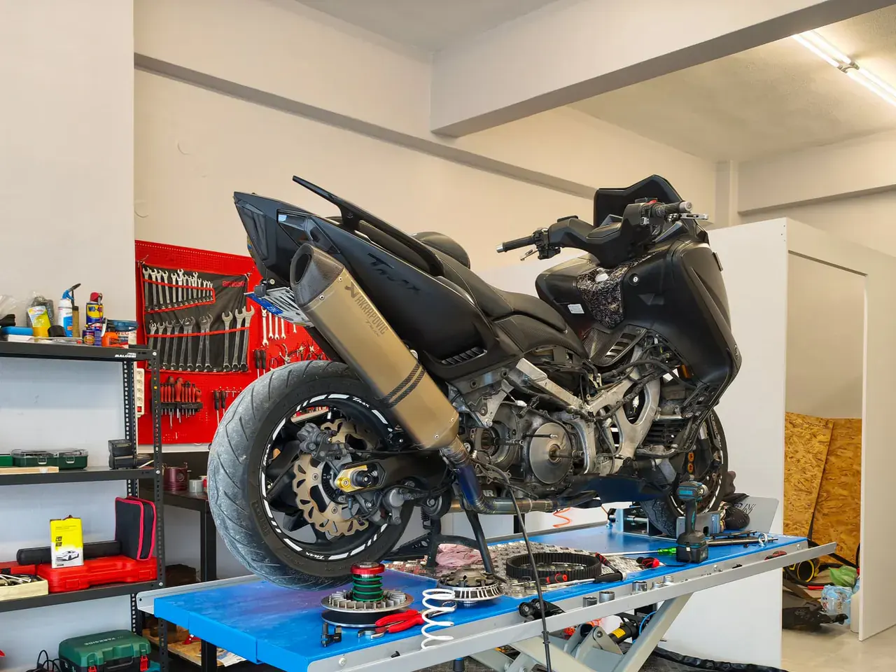 Scooter στο ψαλιδωτό ανυψωτικό με ανοιχτό κινητήρα, έτοιμο για διάγνωση.